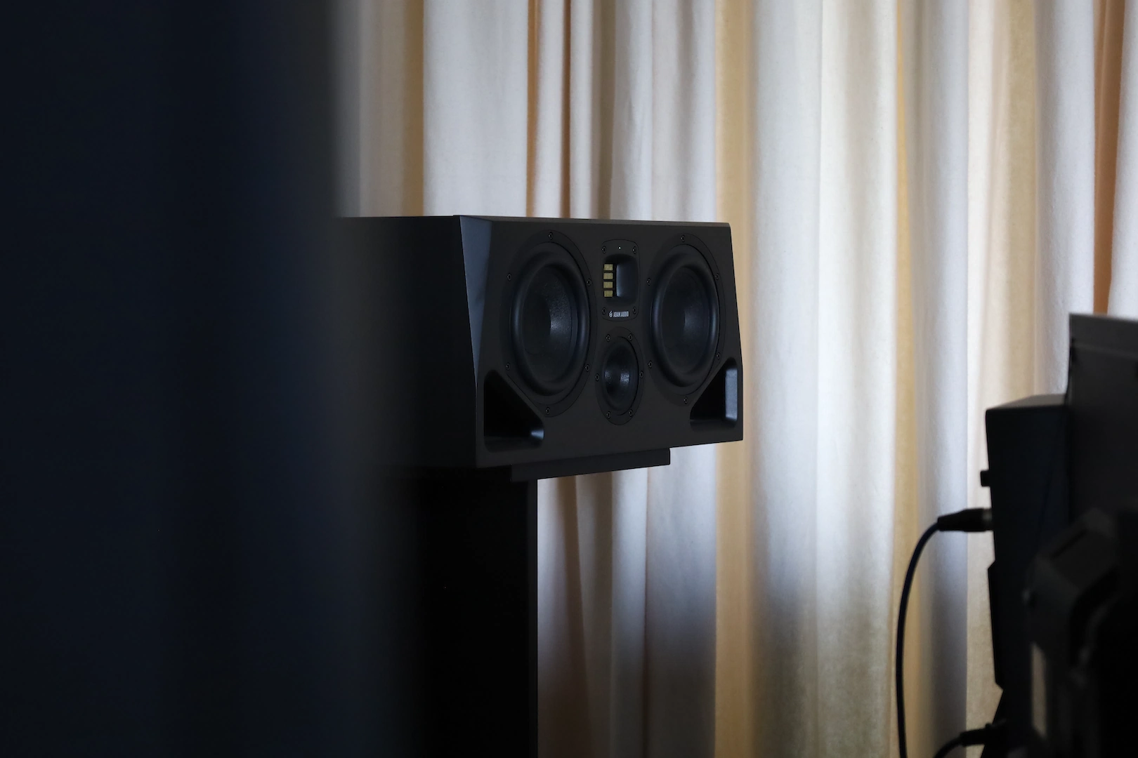ADAM Audio Studiomonitor vor Studiovorhang