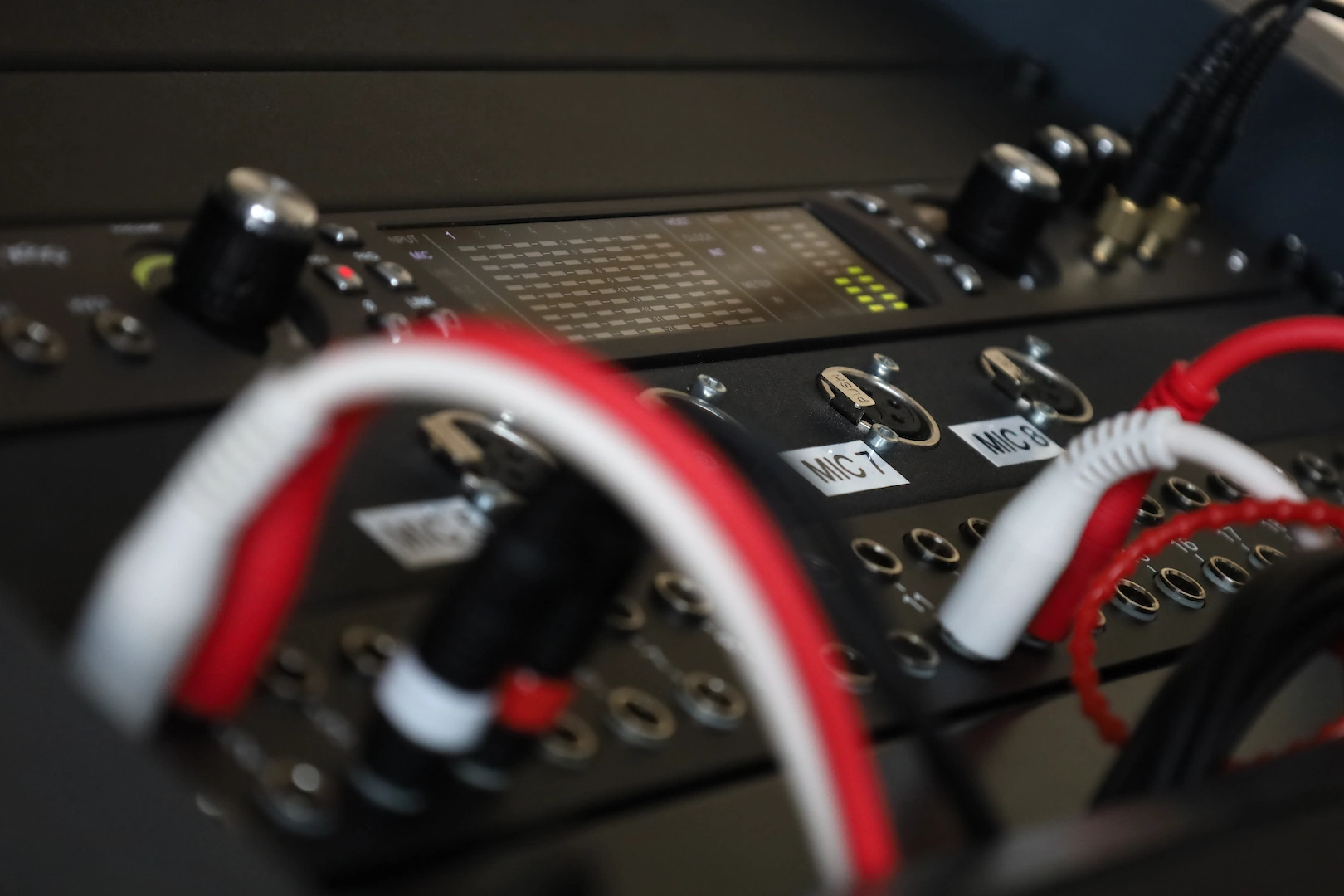Patchbay mit roten und weißen Kabeln im Recording-Setup